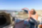 Worker cleaning concrete mixer with hose