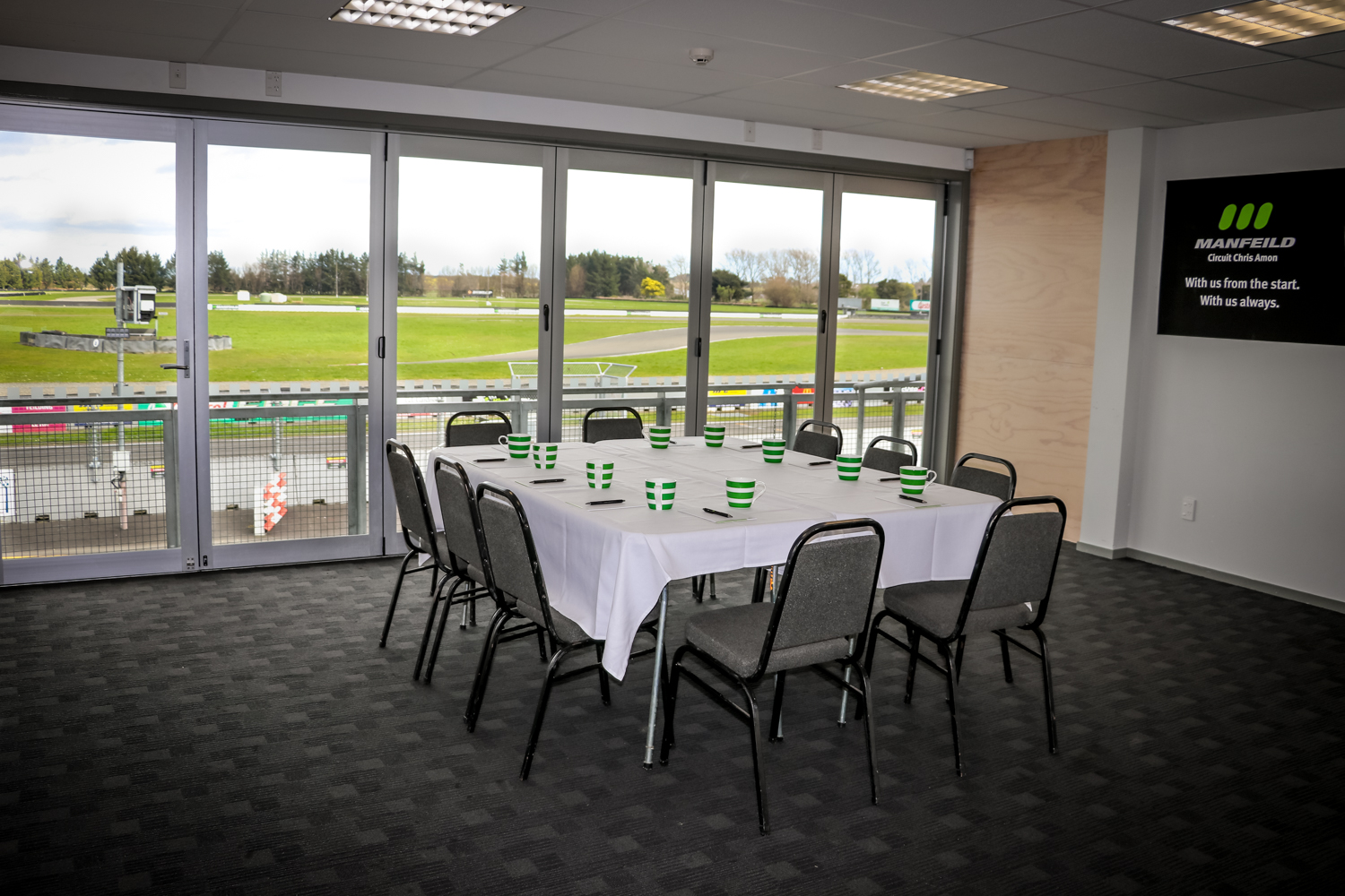 Meeting room overlooks race track, Donington Park logo, table set.