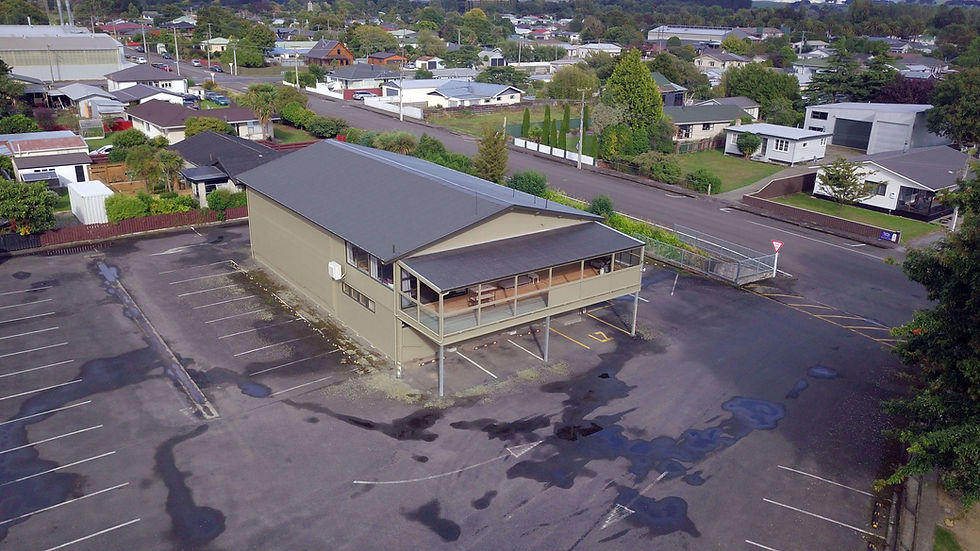 Aerial view of a building in a parking lot, Waireka Trust nearby, New Zealand.