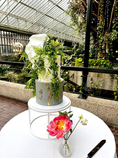 2 tier buttercream wedding cake with concrete effect moulded wafer paper foliage set up at the Barbican Conservatory