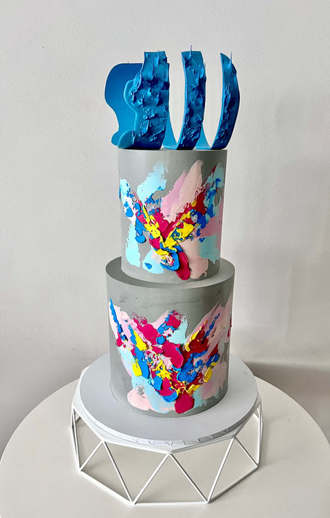 Two tier concrete buttercream wedding cake with abstract palette knife strokes and moulded chocolate topper