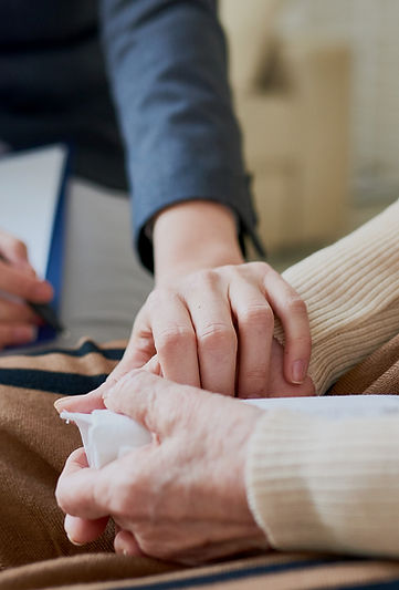 A hospice Social Worker holding the hands of an elderly hospice patient