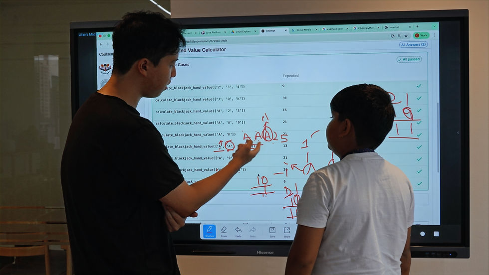 Two people standing in front of a smart board. The teacher writes calculations with a red marker on a screen displaying code.
