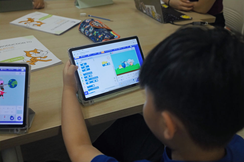 A child in a classroom learning to code with Scratch on a tablet.