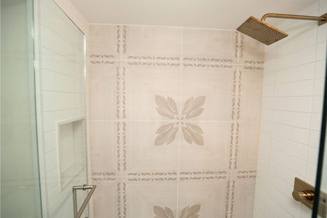 a shower with a floral design on the tiles