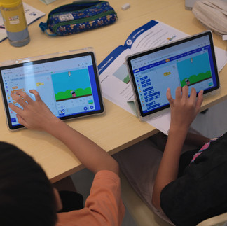 Our students learning to code a game in our Scratch coding class.