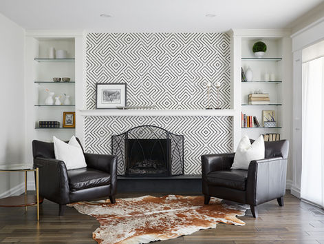 a living room with two leather chairs and a fireplace