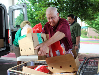 Northwest Arkansas Food Bank’s Volunteer of the Year Tommy Wilson of Elkins helps load boxes of food