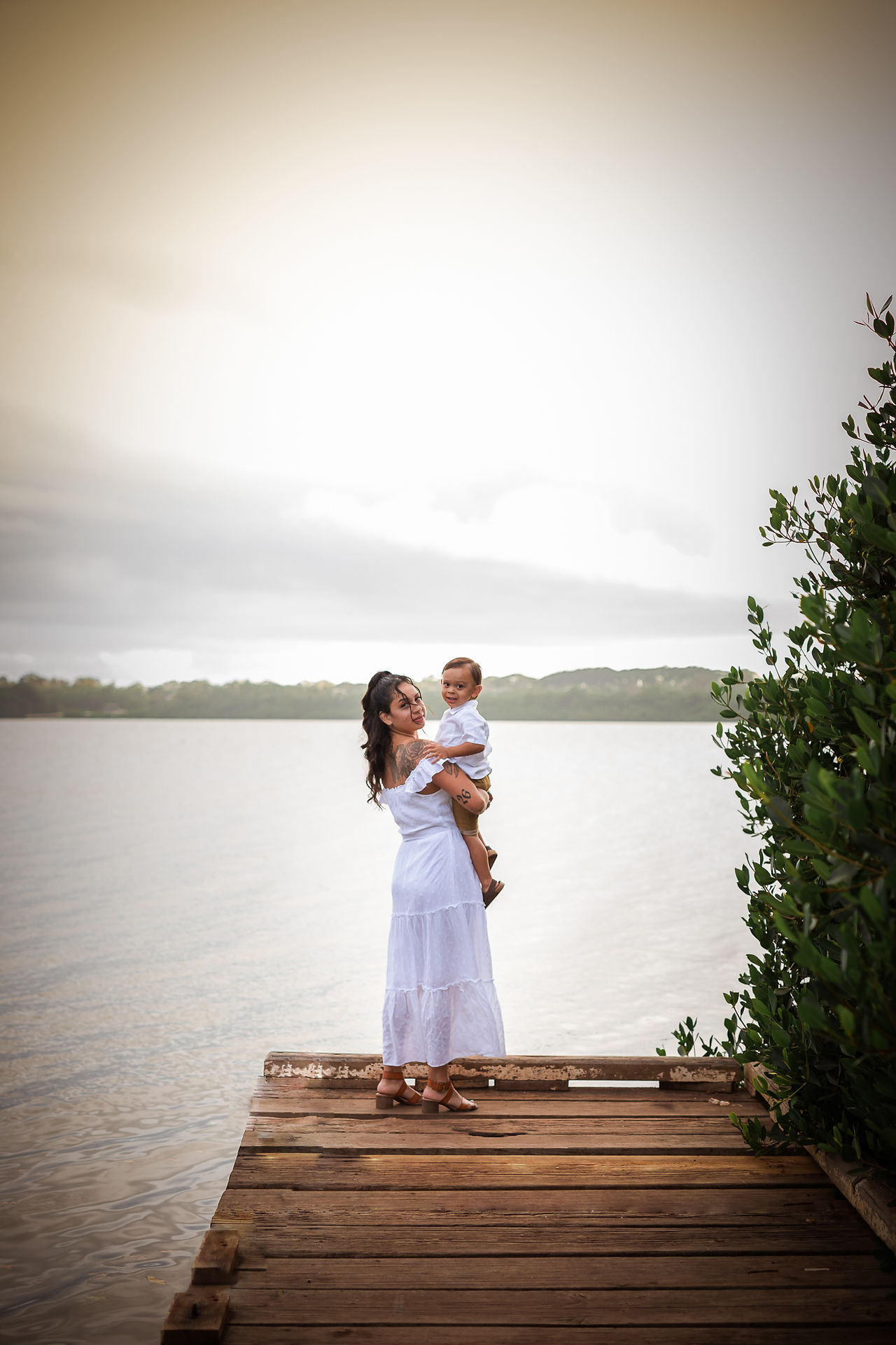 Mom and son looking back while standing on the pier