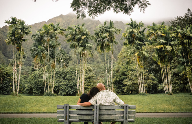 Couple sitting on the bench looking at the mountain