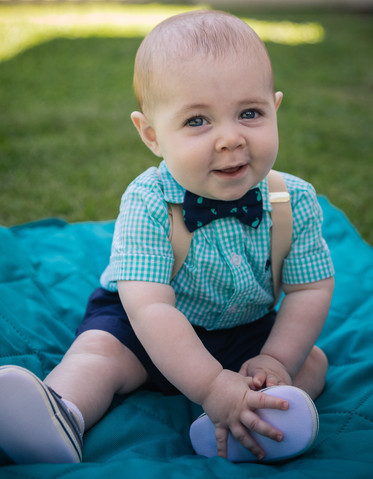 Son sitting up smiling for the camera