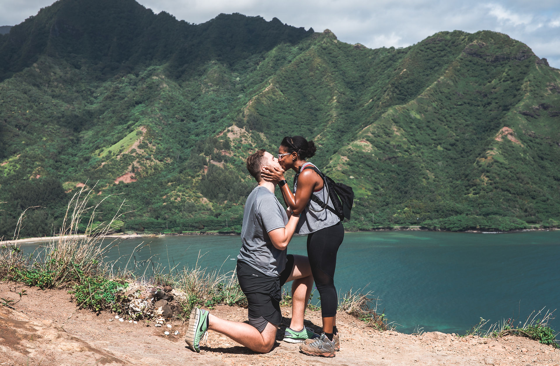 couple kisses while boyfriend kneeling down