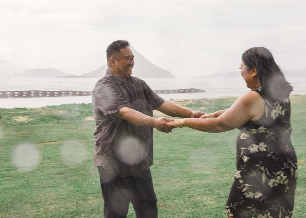 Couple hand in hand dancing in the rain
