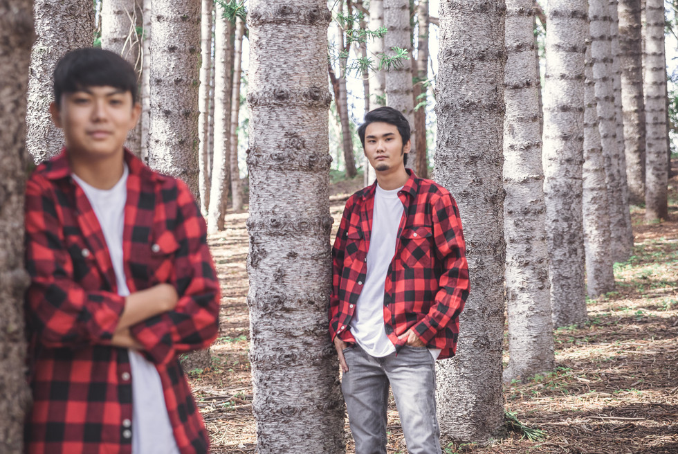 Siblings leaning on tree