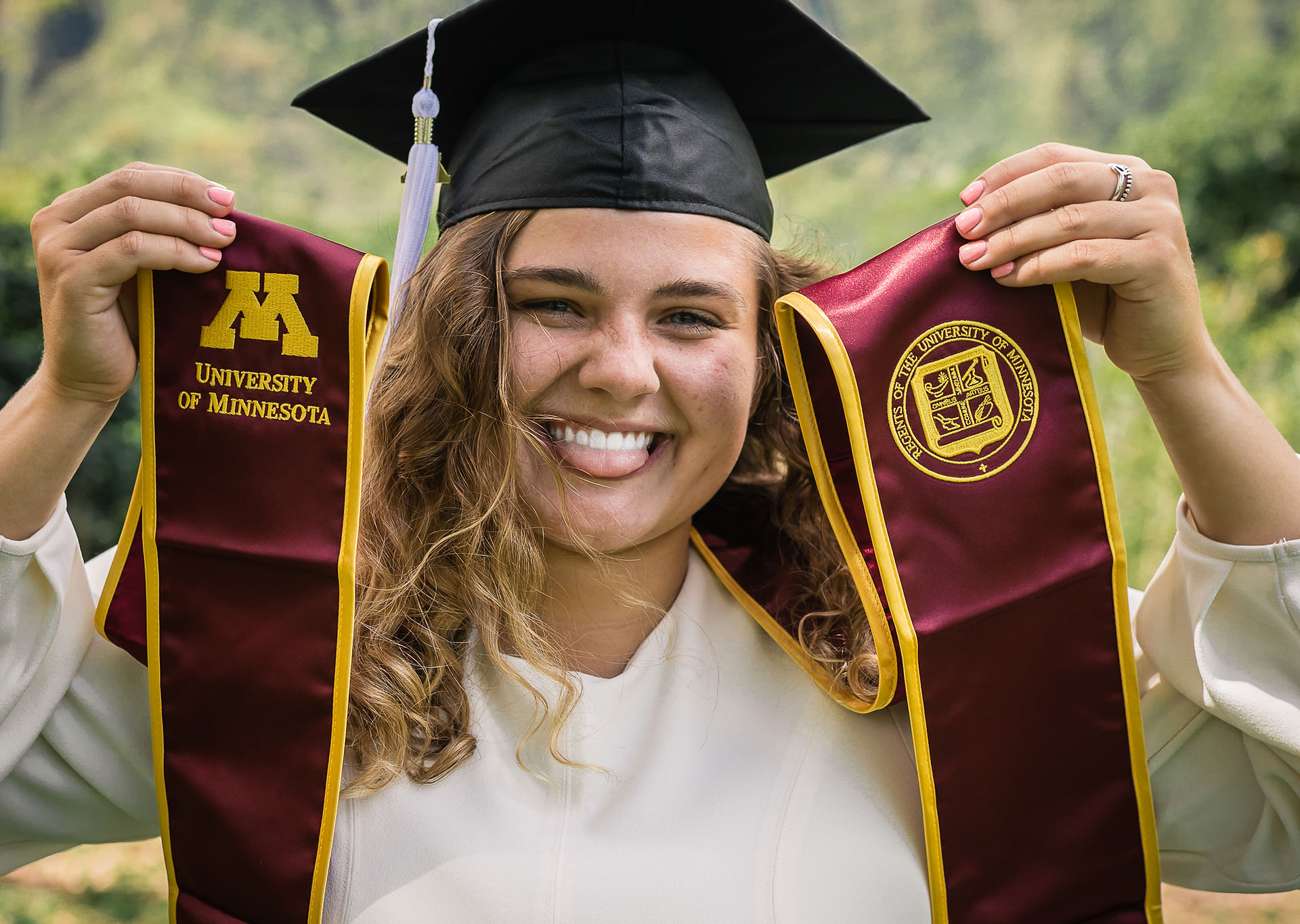 graduate holding up college sash