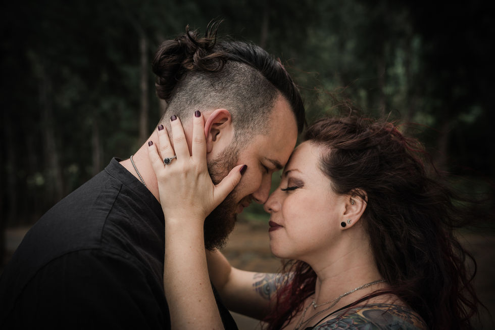girl holding guys face in her hand having a moment