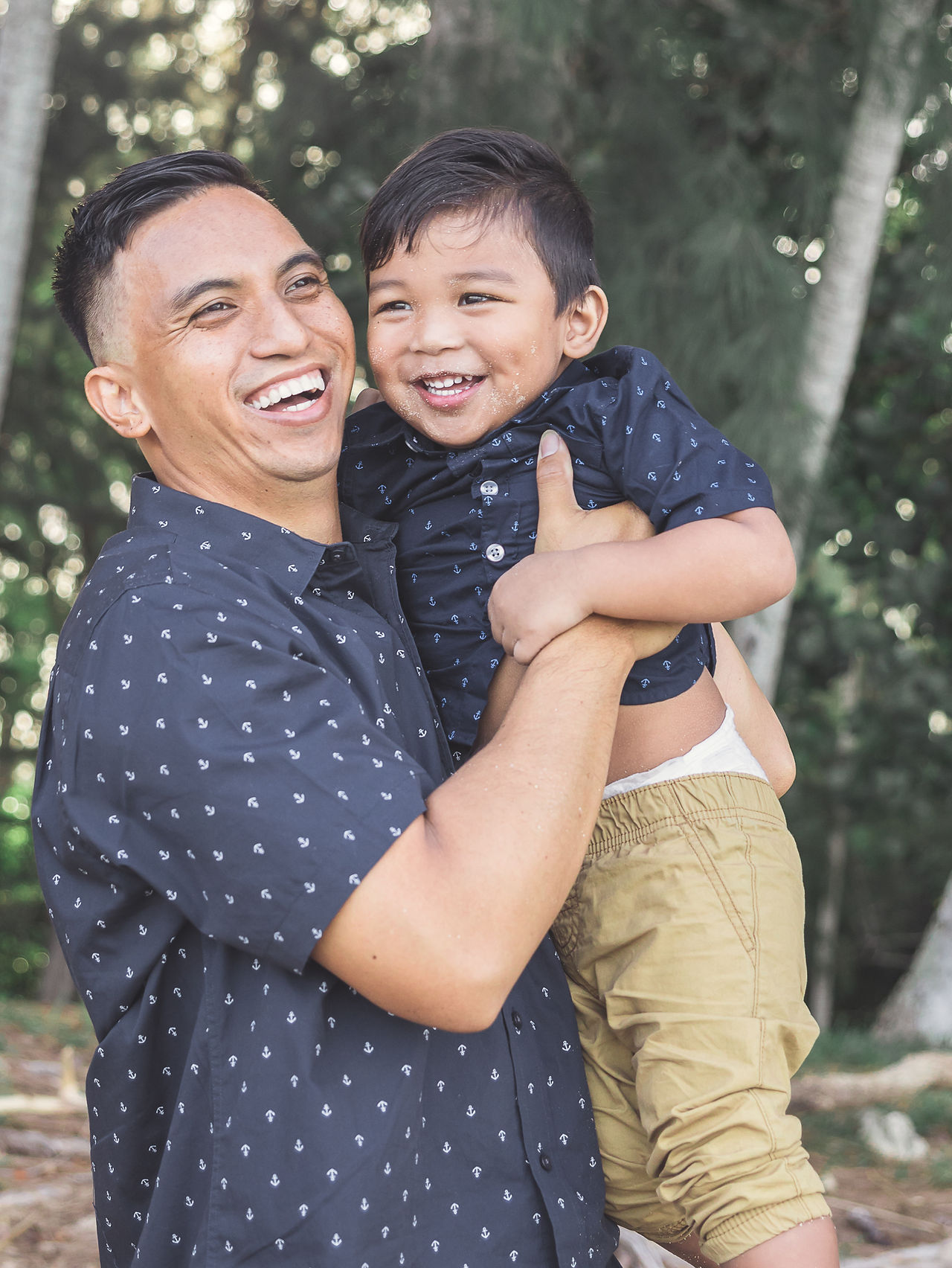 Dad holding son and laughing