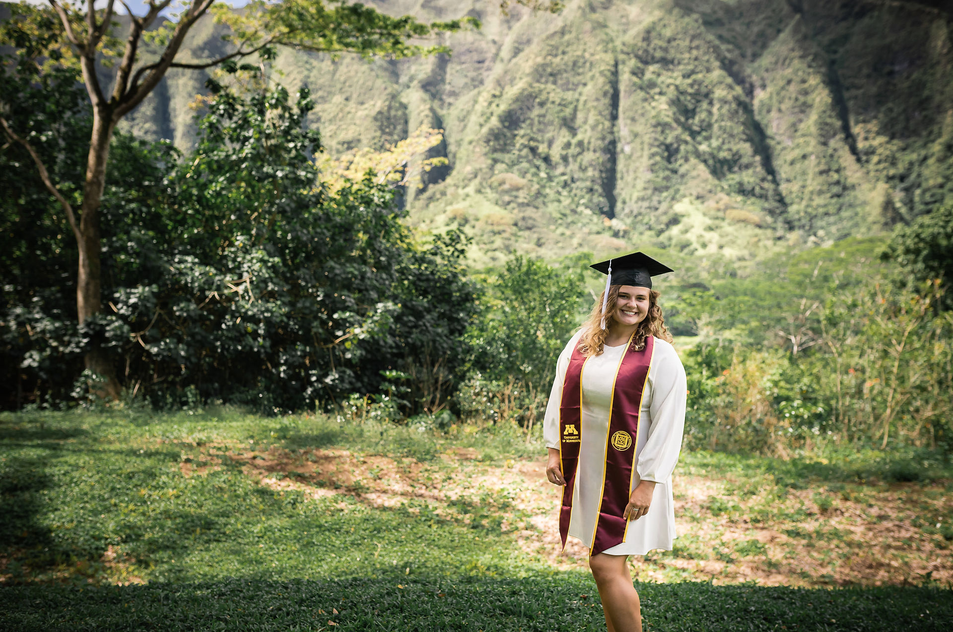 senior college graduate posing in front of mountain back drop