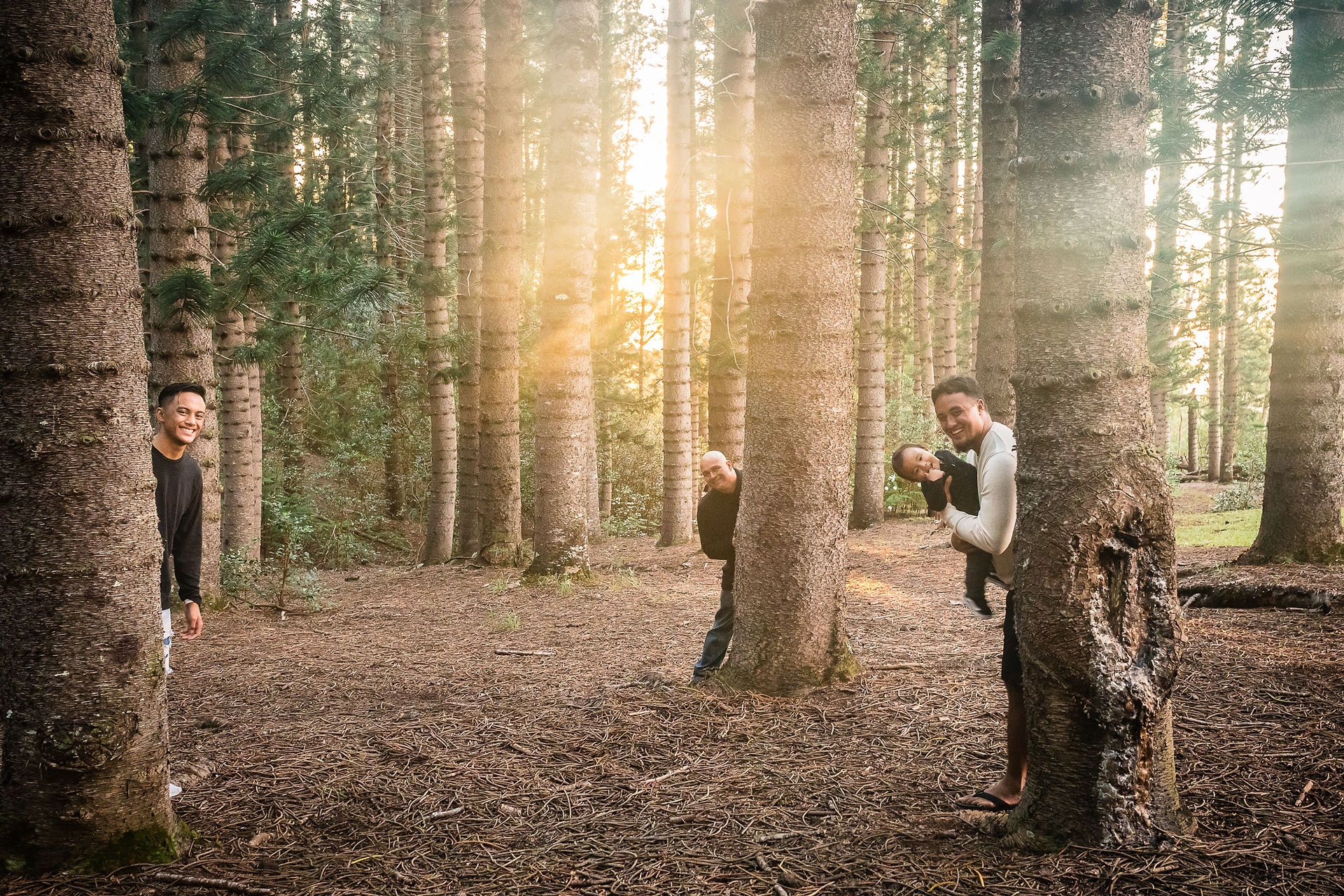 Dad and sons playing peek-boo behind the trees