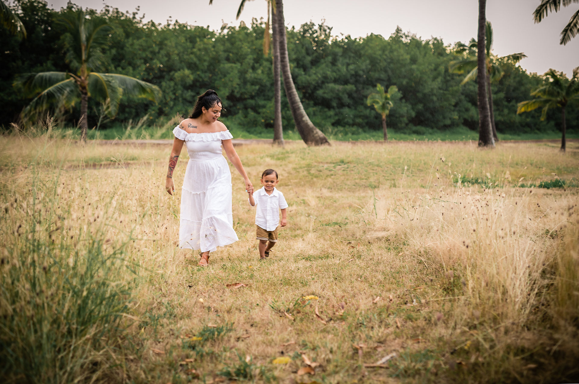 Mom and son walking through a field of dead weeds