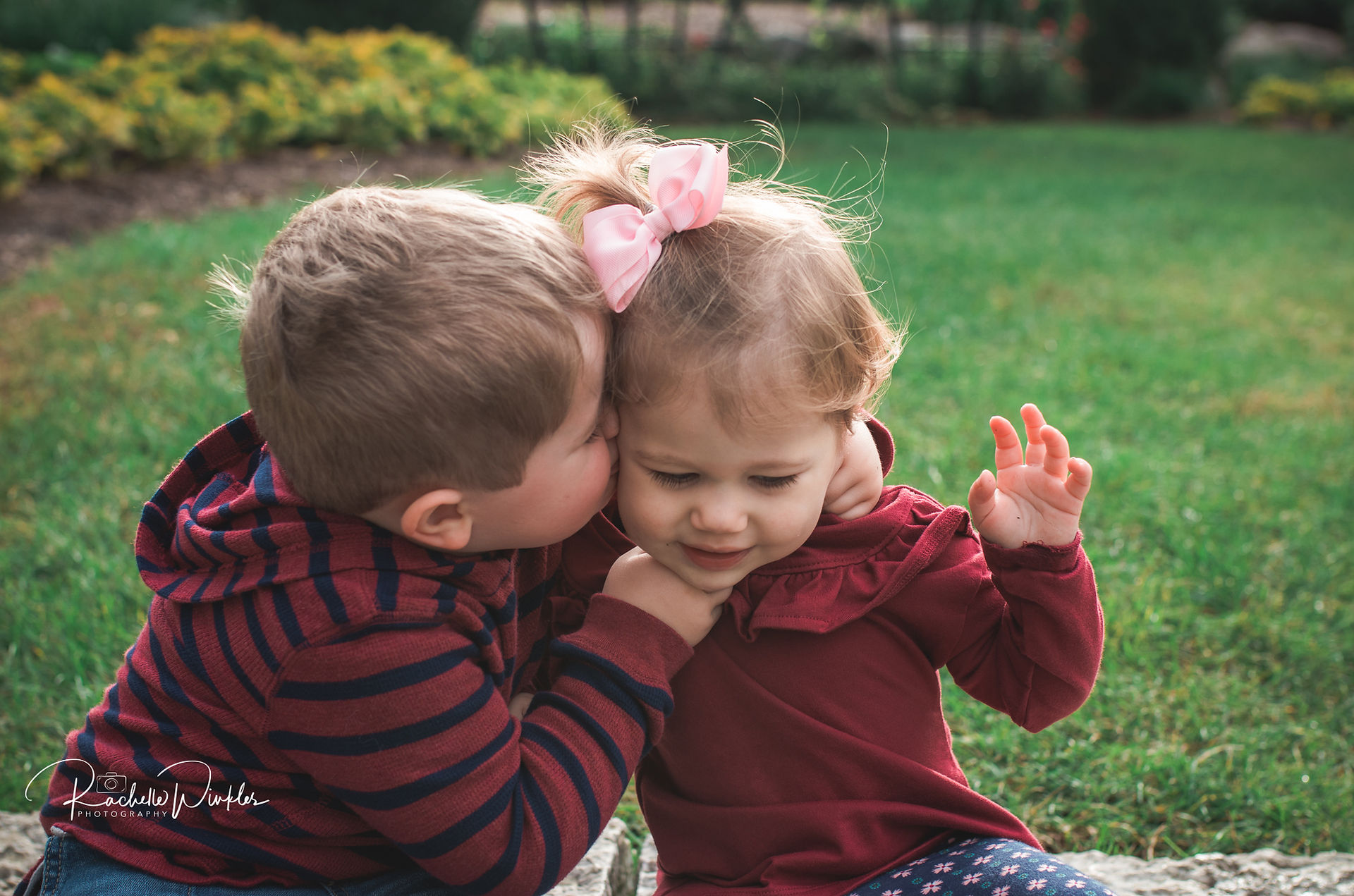 Big brother kissing little sister on cheek