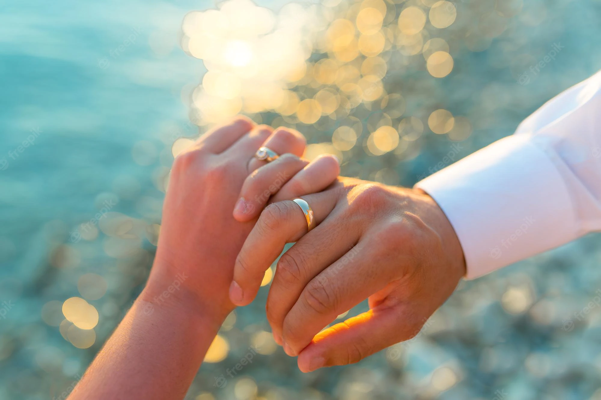 couple-mariage-main-dans-main-fond-coucher-soleil-mer_609048-103.webp