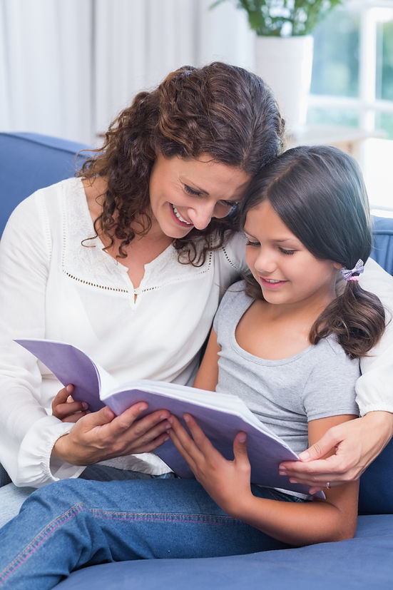 happy-mother-daughter-sitting-couch-reading-book.jpg