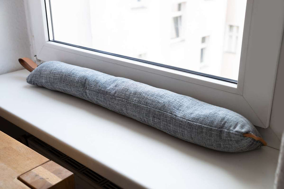 A draft blocker in front of a window.