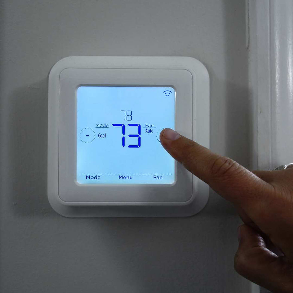 A person adjusts their thermostat.