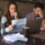 A couple stressfully looks over their increased utility bills.
