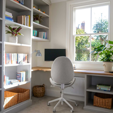 Custom-built home office with bookcase and fitted desk in green-painted cabinetry