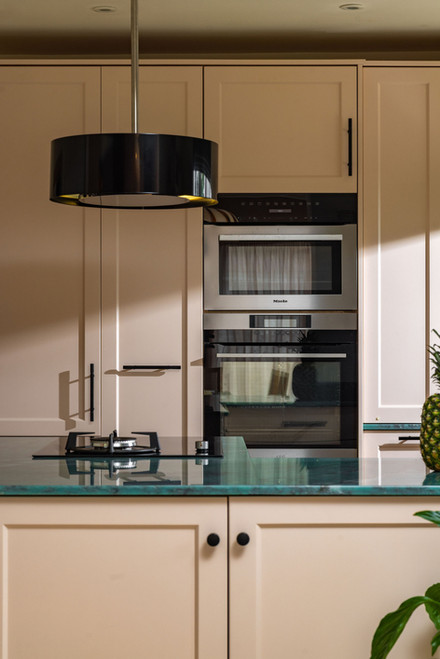 Contemporary cream kitchen with integrated ovens and modern appliances designed in Hampshire