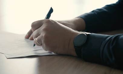 main qui tient un crayon pour signer un papier