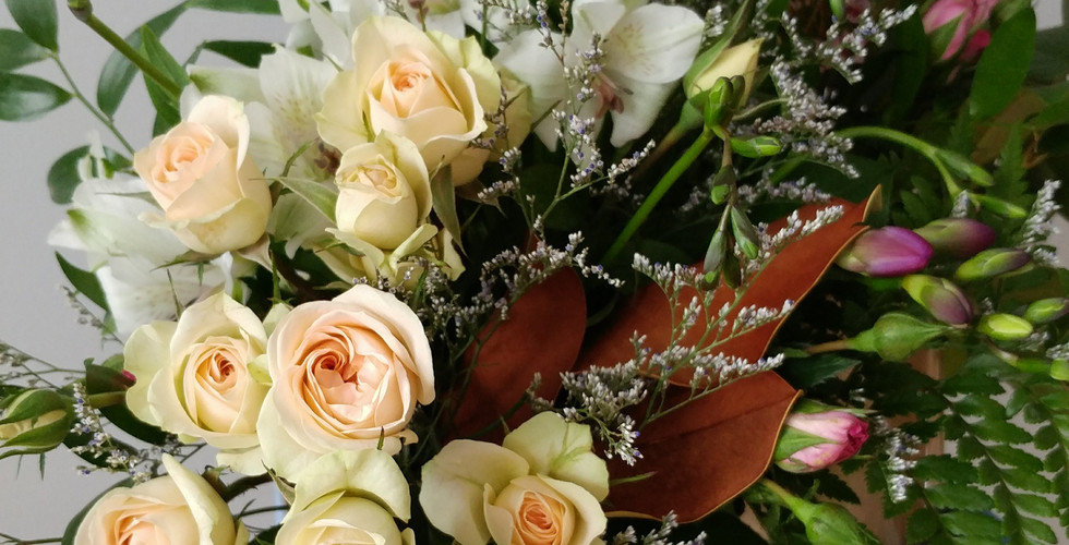 A beautiful bouquet of cream roses and other plants representing many virtues of Mary