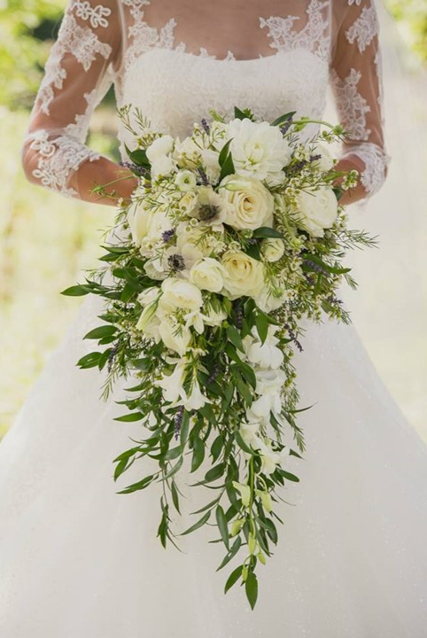 a beautiful bridal bouquet of white flowers and greenery representing many grat things not done by impulse but by a series of small things symbolizing the enduring spark of eros in relationships and the deep, faithful bond of philia—the love of true friendship and connection.