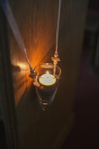 Church décor for a wedding ceremony, with flowers, candles, and thoughtful design elements that bring the sacred space to life in celebration of love. church wedding decor, pew, a tealight in a glass cone hanging on white ribbon with pearls.