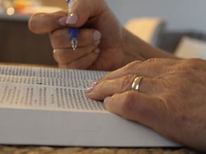 otwarta Biblia i dłoń wskazująca na werset, a druga z długopisem do robienia notatek. Bóg czuwa nad nami – Psalm 121 przypomina o tym. Zakończenie Wielkiego Postu moment na ciszę medialną i spotkanie z Bogiem.