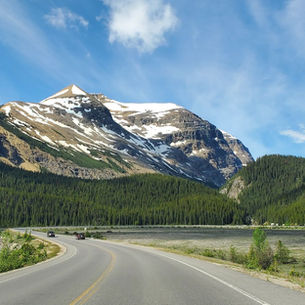A quiet mountain valley with a single path winding through it, shrouded in mist. A strong, ancient rock stands in the foreground—symbolizing God as a fortress, unmovable and sheltering.