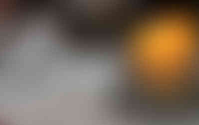 A yellow burning candle and white wooden LOVE sign symbolizing St. Joseph's virtues.