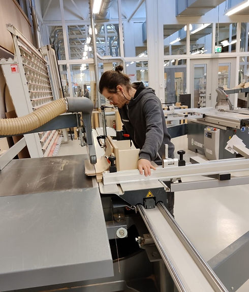 persoon zaagt een onderdeel van een maatwerk kast op formaatzaag