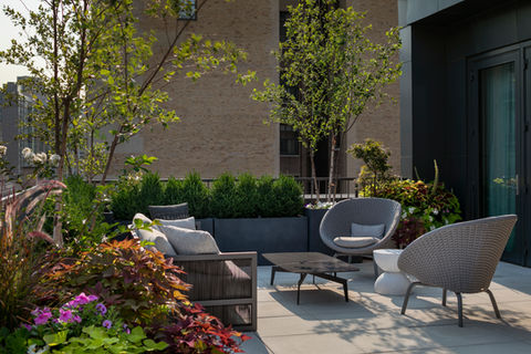 This modern Brooklyn rooftop patio landscape design is a stunning transformation that blends style, functionality, and breathtaking views of the Manhattan skyline. The design features low-maintenance artificial turf, creating a lush, green aesthetic year-round without the need for constant upkeep. The space is thoughtfully crafted to maximize relaxation and entertainment, offering areas for lounging and dining while taking full advantage of the panoramic city views. With a sleek, contemporary design, this rooftop patio becomes a perfect urban retreat, combining modern materials with natural elements for a serene and inviting environment.