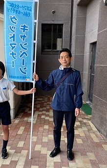 グッドマナーキャンペーンの旗を持って立つ生徒と先生