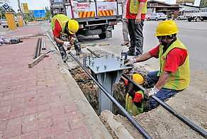 Technicians installing a heavy-duty steel base foundation and anchor bolts for an outdoor pylon sign.