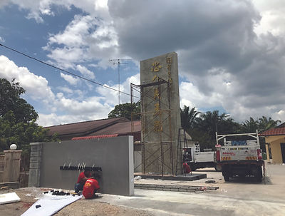 Installation of a grand stone-texture monument sign with gold Chinese 3D lettering using scaffolding and professional equipment.