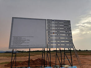 Large professional project site board (Paparan Maklumat Projek) showing developer and consultant details, installed on a heavy-duty steel frame.