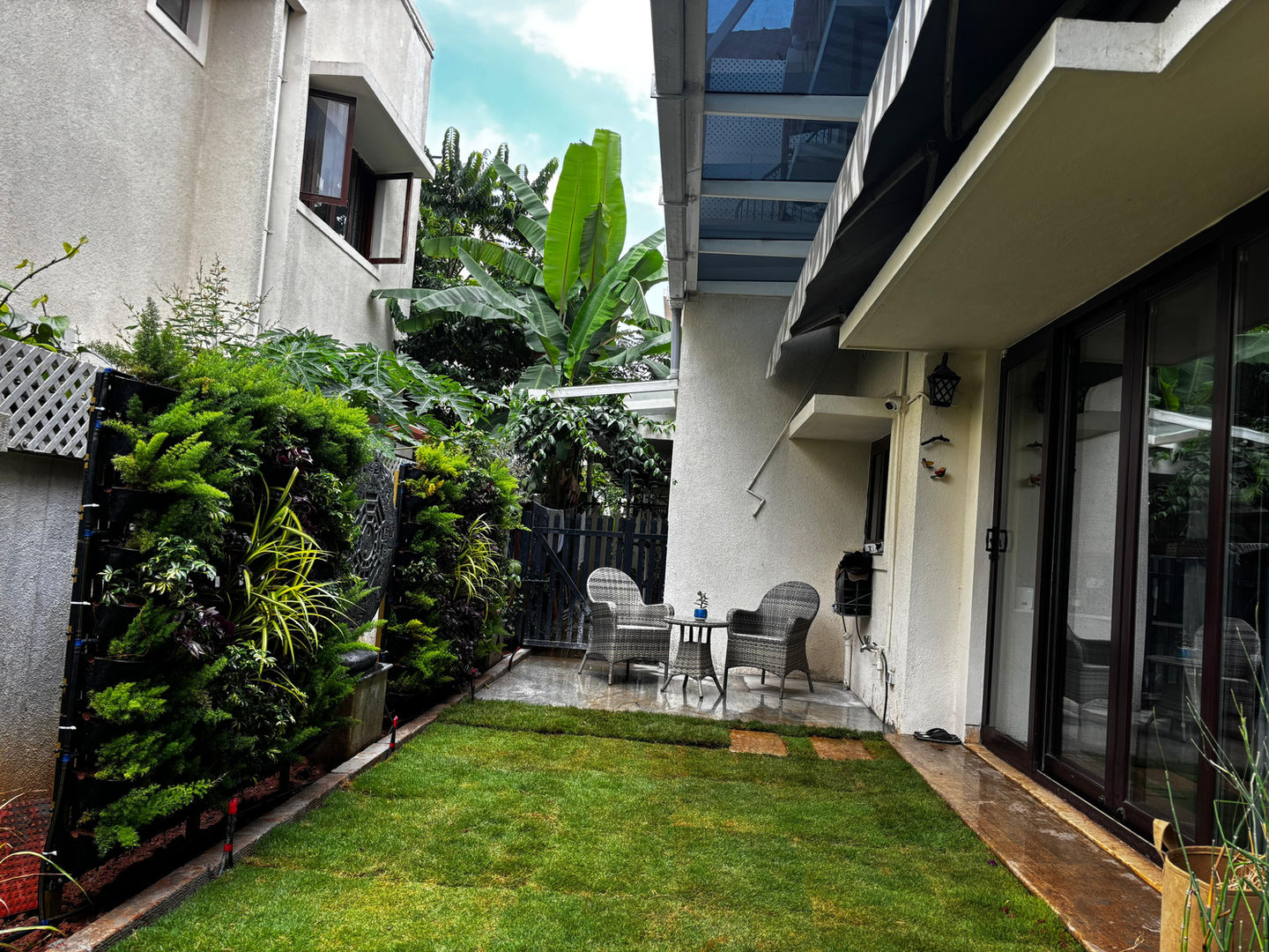 Green backyard with patio furniture, Anantha Landscape in the background.