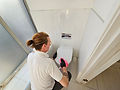 Cleaníge team member cleaning toilets within our client's offices in Bushey.