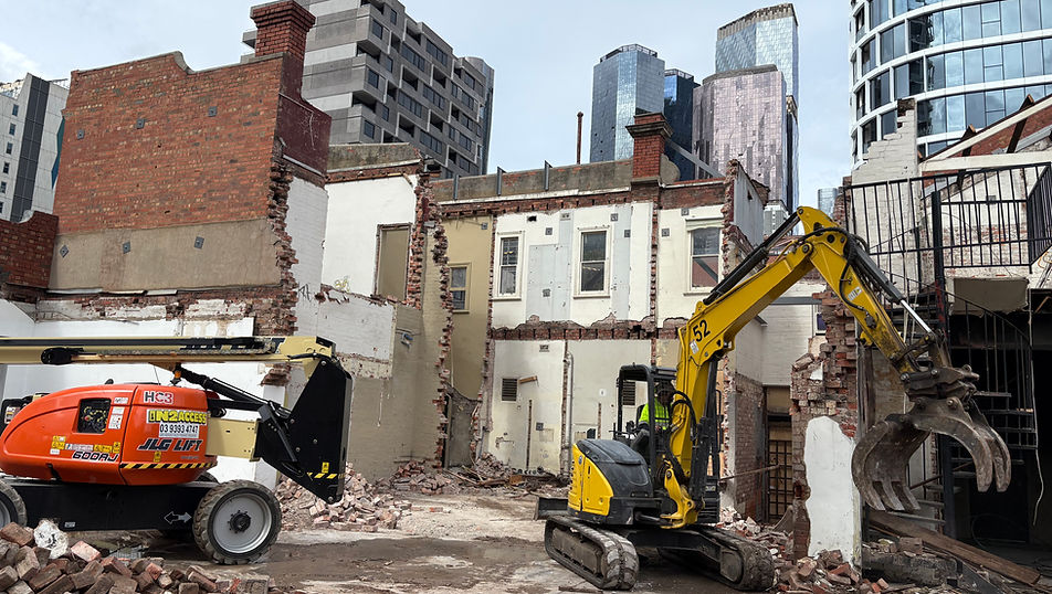 Demolition of industrial buildings at 405–421 Spencer Street, West Melbourne, with heritage brick façades and oven structures retained.