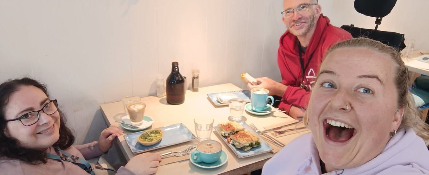 Disability support workers and participants enjoying a community café outing in Melbourne.