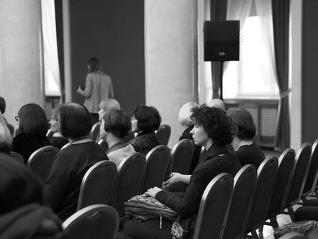 Žmonės sėdintys konferencijoje